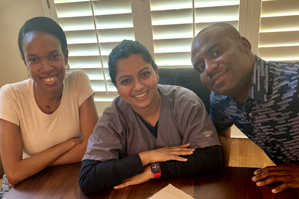 Two female residents with faculty member sitting at a table