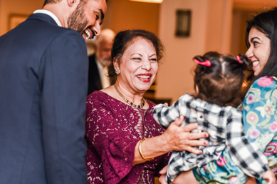 Faculty member smiling at a young female child at the graduation