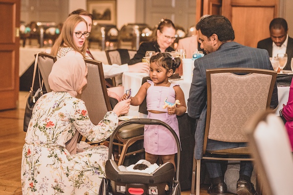 Graduation participant talking to a child at a table