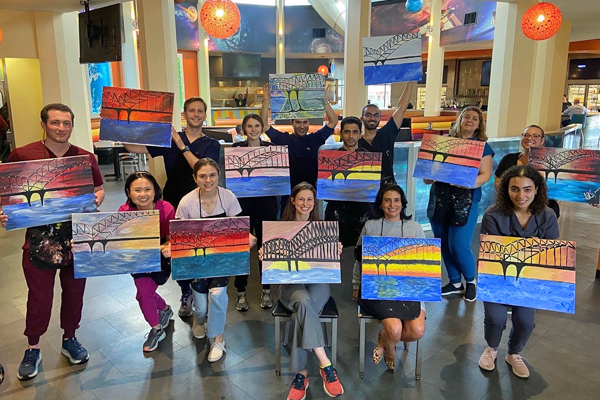 Residents with paintings they made in a class