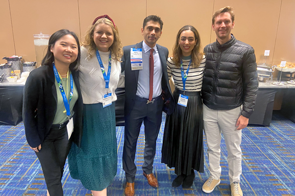 Five residents in a group pose at a conference