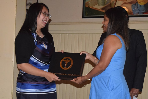 Female fellow receiving certificate from faculty