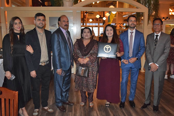 Female fellow, family, and faculty members holding certificate