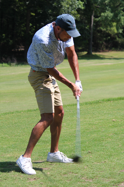 Male resident swinging a golf club