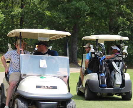 Residents passing each other on the golf course in golf carts