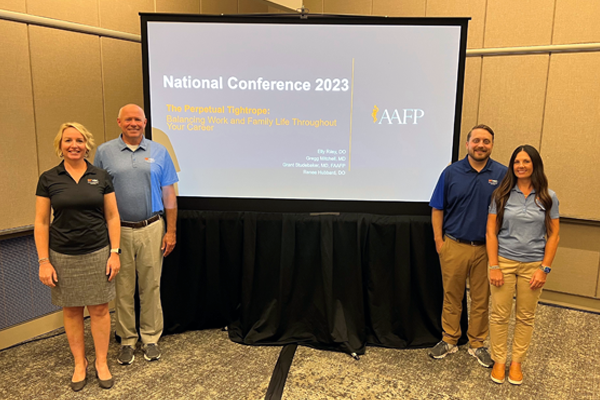 Faculty and residents in front of a presentation screen