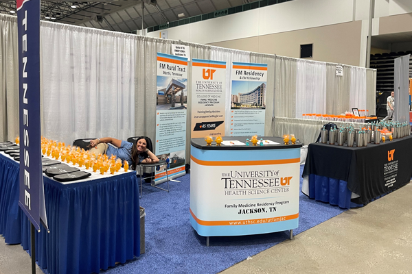 Resident lying down in a chair at the UTHSC booth