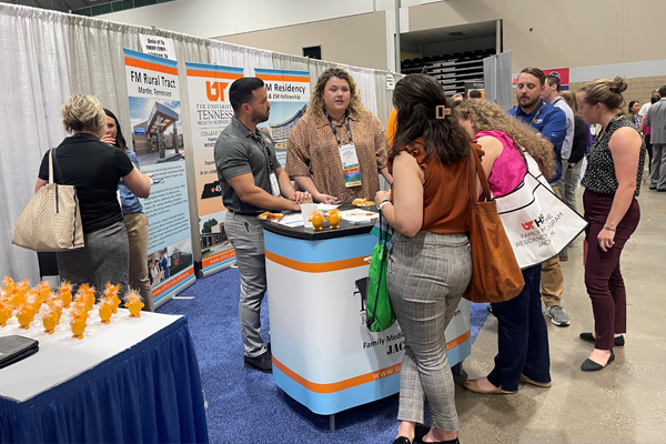 UTHSC residents and faculty helping people at the conference booth