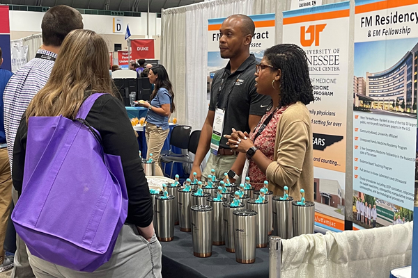 UTHSC residents and faculty helping people at the conference booth