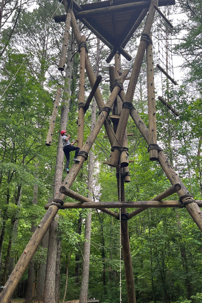 residents climbing up the ropes course