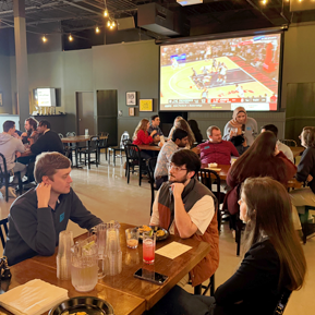 Residents sitting in a restaurant with a television in the background