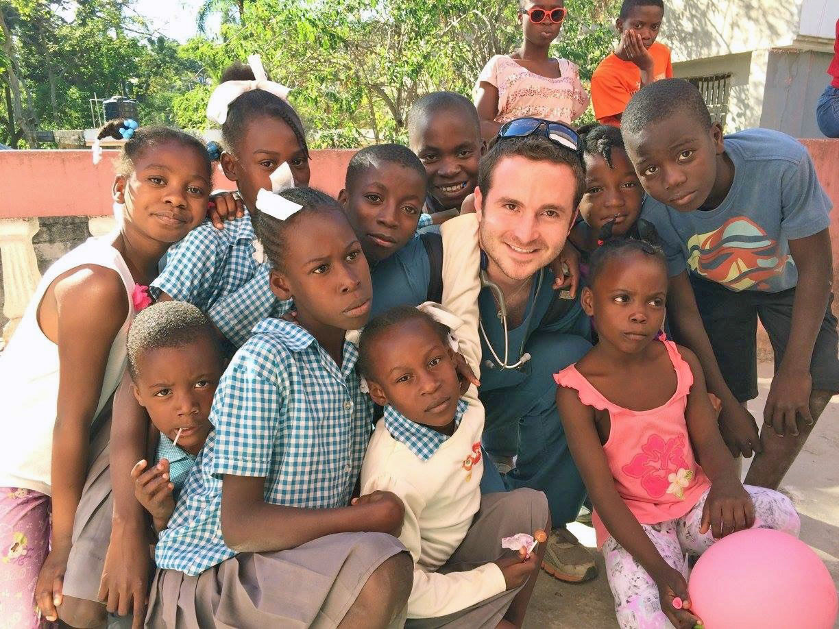 Male doctor surrounded by kids