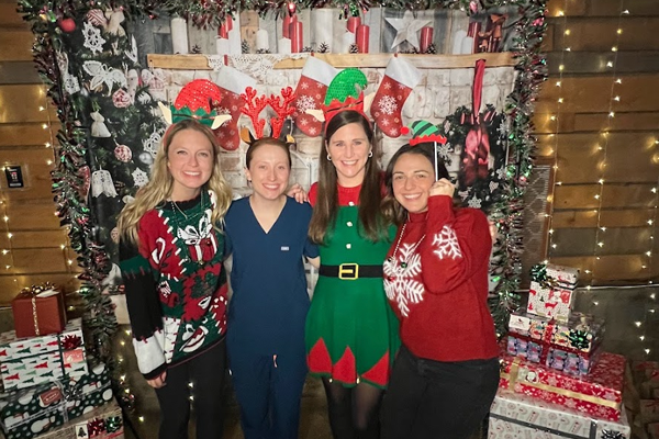 Four female residents at an indoor holiday party