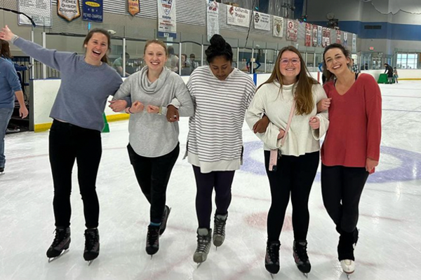 Five female residents skating at an ice rink