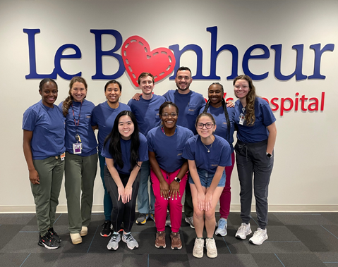 Residents posing before Le Bonheur sign