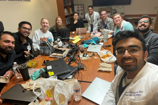 Fellows eating and working in a conference room