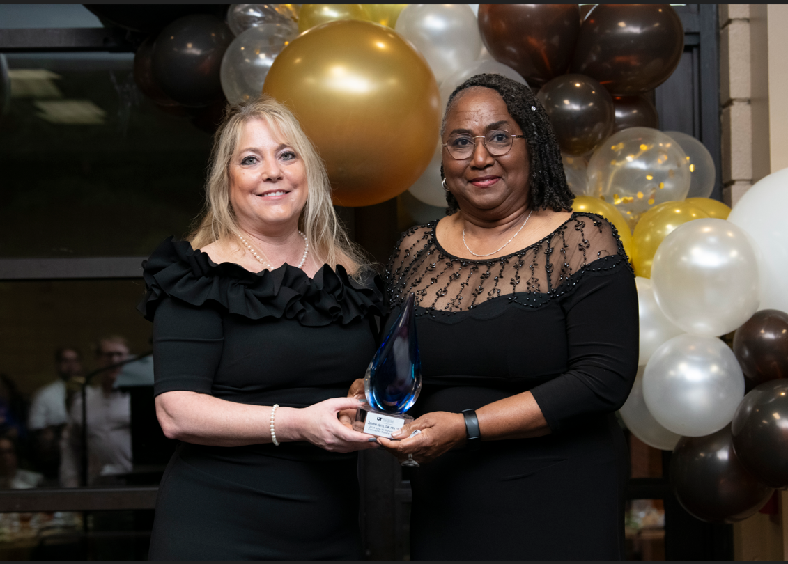 Two women holding award