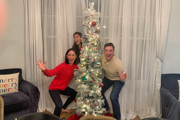 Fellows in front of a holiday tree