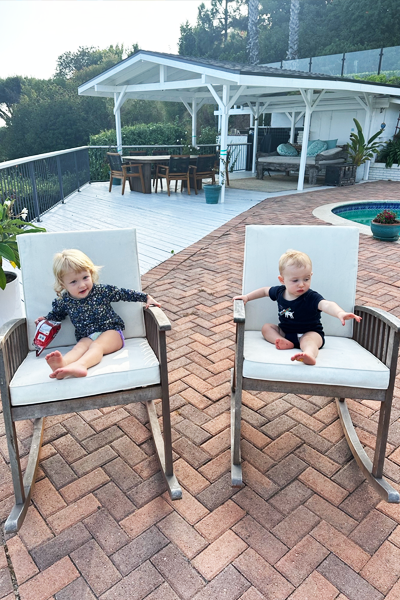 Fellows's babies in chairs outside beside a pool