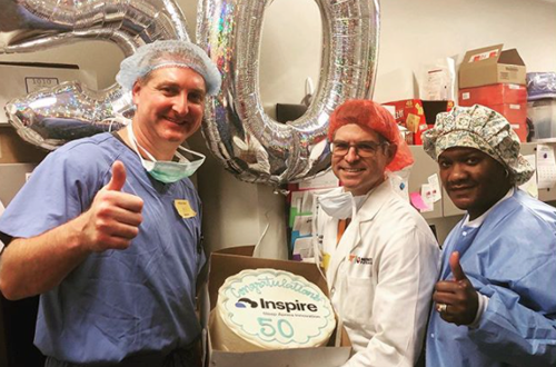 three doctors holding a cake