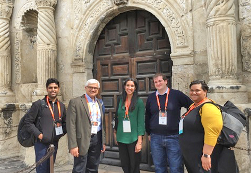 Smiling fellows and faculty outside