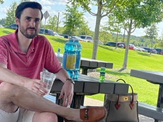 Resident sitting on a bench at graduation celebration outdoors