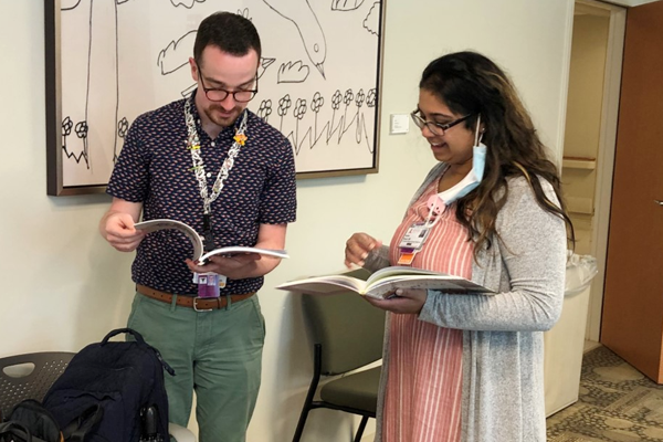 Two residents looking at a book in a classroom