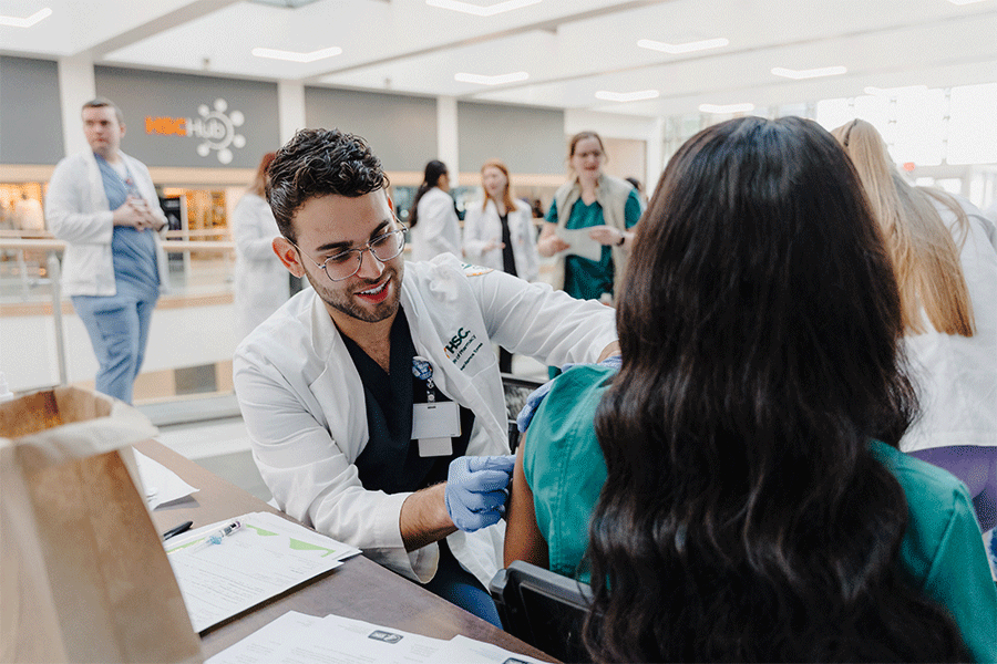 Pharmacy student administers flu shot.