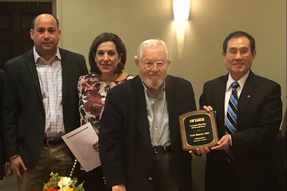 Dr. Clark Blatteis stands with other Department of Physiology faculty as Dr. Sun presents him with a plaque.