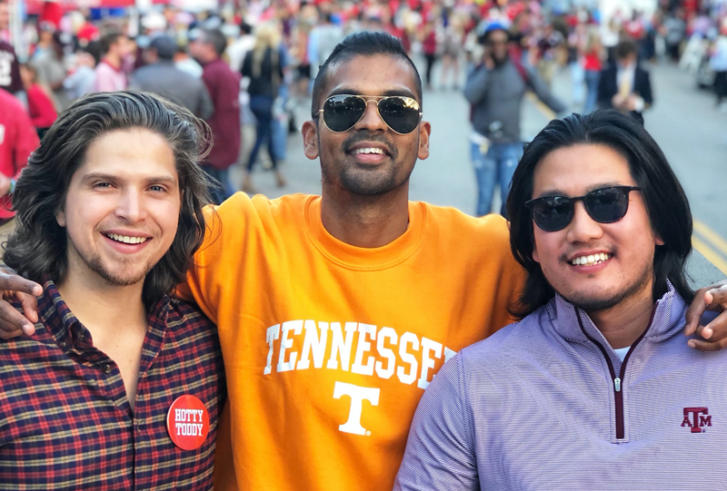 three residents outside a football game