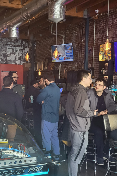 Residents mingling and talking at a bar indoors