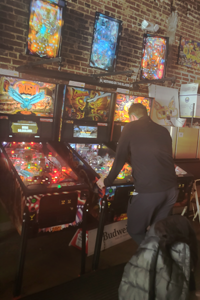 Resident playing pinball machine