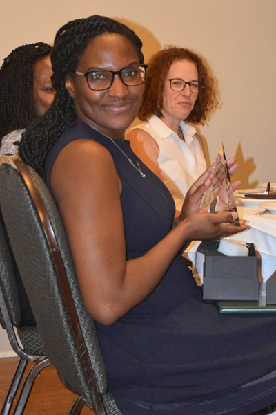 Graduates holding certificate at the table